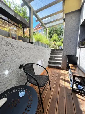 a patio with a table and chairs on a deck at Apartment Sport & Sauna Prague in Prague