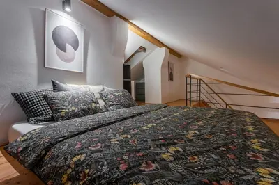 a bedroom with a large bed and a staircase at Parkview Studio in Prague