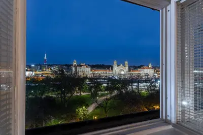 a window with a view of a city at night at Parkview Studio in Prague