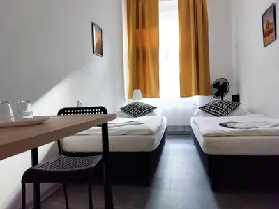 a room with two beds and a table and a window at Zlatý pokoj v centru Prahy B1 in Prague