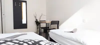 a bedroom with two beds and a small table at Zlatý pokoj v centru Prahy B1 in Prague