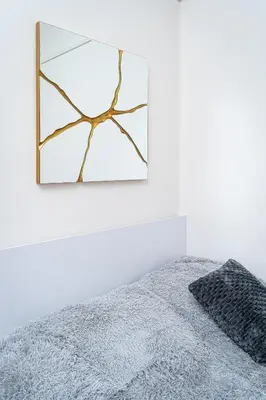 a mirror hanging on a wall next to a bed at Victory Castle Suite in Prague