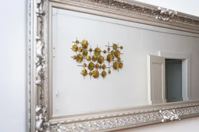 a mirror with a bunch of birds hanging on a wall at Victory Castle Suite in Prague