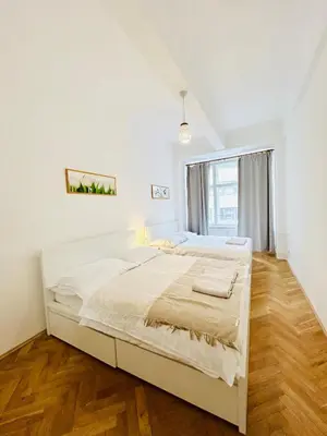 a white bedroom with a large bed and a window at New apartment near Wenceslas Square in Prague