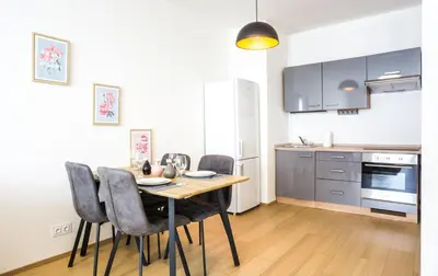 a kitchen with a table and chairs in a room at Waltrovka One bed room apartment in Prague