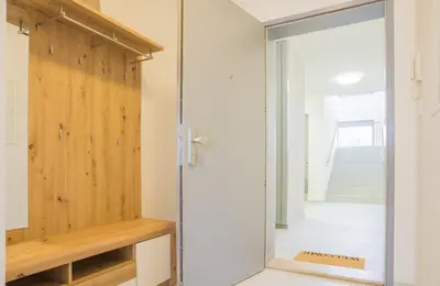 a glass pivot door in a room with a staircase at Waltrovka One bed room apartment in Prague