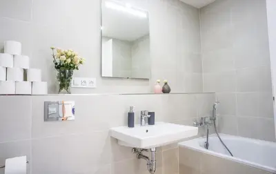 a white bathroom with a sink and a bath tub at Waltrovka One bed room apartment in Prague
