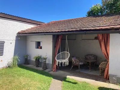 a patio with a swing and a table and chairs at Domek Jiráskova in Dobříš