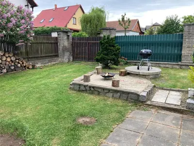 a backyard with a barbecue grill in a yard at Domek Jiráskova in Dobříš