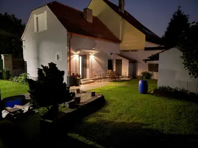 a small white house with a yard at night at Domek Jiráskova in Dobříš