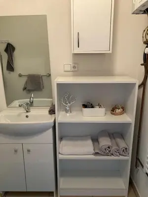 a bathroom with a sink and a white cabinet and towels at Domek Jiráskova in Dobříš