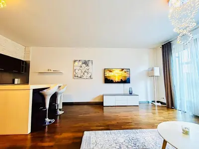a living room with a kitchen and a table at Old Brewery Terrace Apartment in Prague