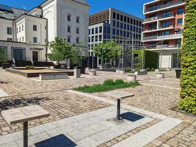 a courtyard with two benches in a city with buildings at Old Brewery Terrace Apartment in Prague