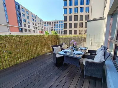 a wooden deck with a table and chairs on a balcony at Old Brewery Terrace Apartment in Prague