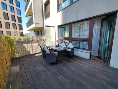 a wooden deck with a table and chairs on a building at Old Brewery Terrace Apartment in Prague