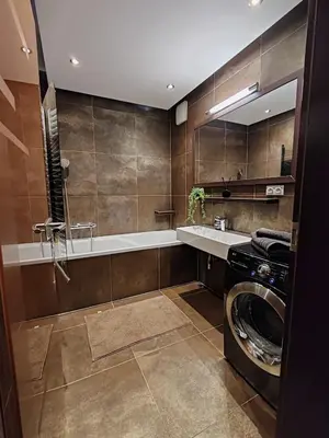 a bathroom with a washing machine and a sink at Old Brewery Terrace Apartment in Prague