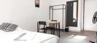 a bedroom with a bed and a table and a mirror at Fantastický pokoj v Praze na Letné B3 in Prague