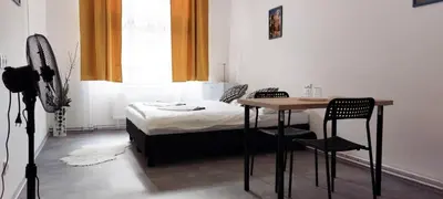 a bedroom with a bed and a table and chairs at Fantastický pokoj v Praze na Letné B3 in Prague