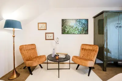 a living room with two chairs and a table at Prague Days - Two-Bedroom Maisonette with AC and Terrace with Grill in Vinohrady in Prague
