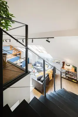 a living room with a staircase and a couch at Prague Days - Two-Bedroom Maisonette with AC and Terrace with Grill in Vinohrady in Prague