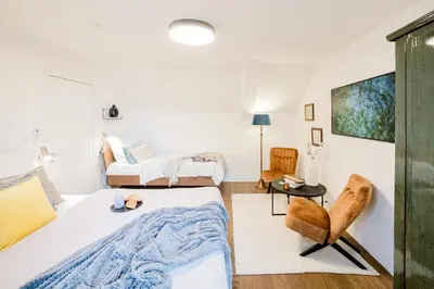 a bedroom with a bed and a chair at Prague Days - Two-Bedroom Maisonette with AC and Terrace with Grill in Vinohrady in Prague