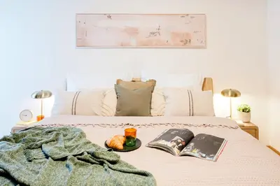 a bed with a plate of fruit and books on it at Prague Days - Two-Bedroom Maisonette with AC and Terrace with Grill in Vinohrady in Prague
