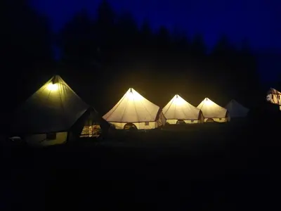 a row of tents lit up at night at Kemp v areálu pivovaru Malý Janek z Jinec in Příbram
