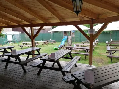 a group of picnic tables sitting under a pavilion at Kemp v areálu pivovaru Malý Janek z Jinec in Příbram