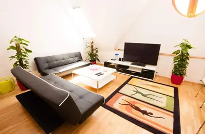 a living room with a couch and a tv at Kozi Loft Residence Prague Old Town in Prague