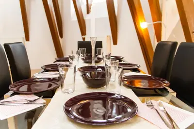 a long table with black plates and glasses on it at Kozi Loft Residence Prague Old Town in Prague