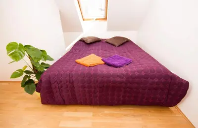 a purple bed with three towels on it in a room at Kozi Loft Residence Prague Old Town in Prague
