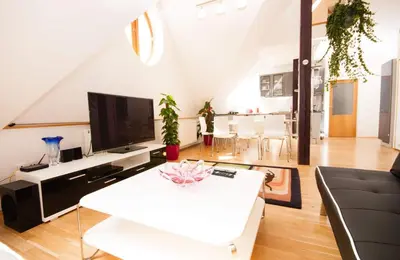 a living room with a white couch and a tv at Kozi Loft Residence Prague Old Town in Prague