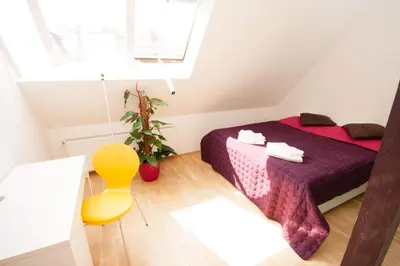 a small room with a bed and a yellow chair at Kozi Loft Residence Prague Old Town in Prague