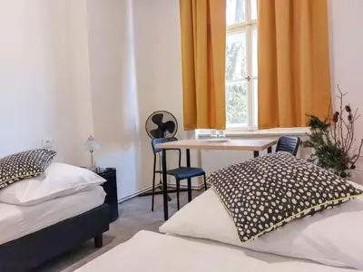 a bedroom with two beds and a table and a window at Soukromý pokoj B4 káva v ceně in Prague