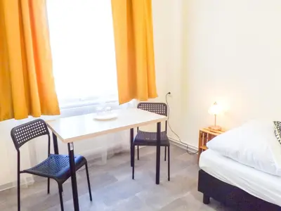 a room with a table and two chairs and a bed at Pokoj v Pražských Holešovicích C1 in Prague