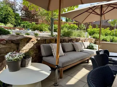 a patio with a couch and a table with an umbrella at Private house with garden in Nový Jáchymov