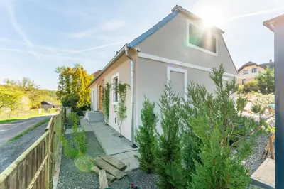a white house with a fence next to it at Private house with garden in Nový Jáchymov