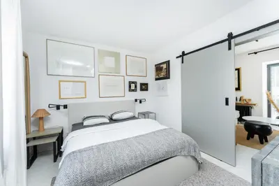a white bedroom with a bed and a sliding glass door at Private house with garden in Nový Jáchymov