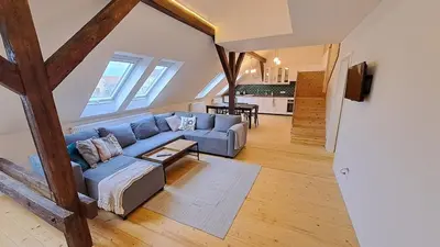 a living room with a blue couch and a table at Prague Urban Oasis Loft in Prague