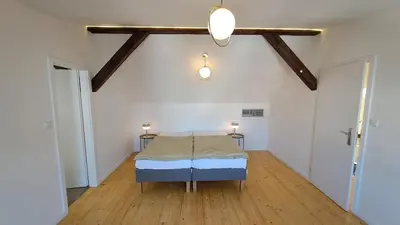 a bedroom with a bed in a room with wooden floors at Prague Urban Oasis Loft in Prague