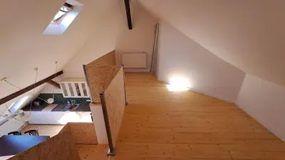 an attic room with a staircase with a light on it at Prague Urban Oasis Loft in Prague