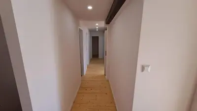 a hallway with white walls and a wooden floor at Prague Urban Oasis Loft in Prague