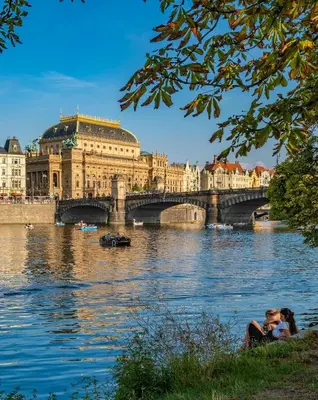 a bridge over a river in front of a building at Cool room on Letná D1 in Prague