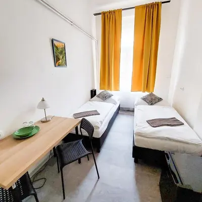 a room with two beds and a desk and a table at Cute room D2 Prague 7 in Prague