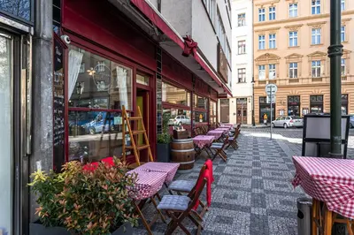 a row of tables and chairs outside of a restaurant at FAMILY 2 BEDROOM APARTMENT IN THE CITY CENTRE - by WISHLIST PRAGUE in Prague