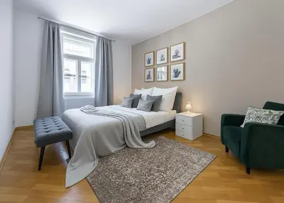 a bedroom with a bed and a chair and a window at FAMILY 2 BEDROOM APARTMENT IN THE CITY CENTRE - by WISHLIST PRAGUE in Prague