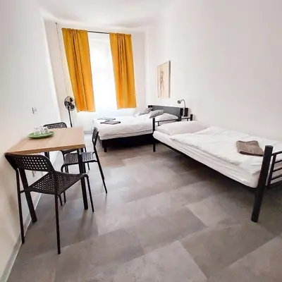 a room with two beds and a table and chairs at Cozy relax Praha Letná D3 in Prague