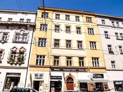 a large yellow building on a street with cars parked in front at Spacious room E1 in centre of Prague in Prague