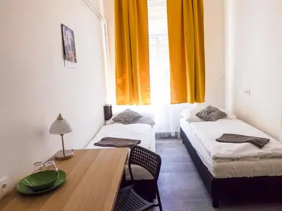 a room with two beds and a table and a window at Letenský pokoj Milada E2 in Prague
