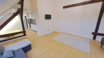 a living room with a couch and a tv on a wall at Prague Panorama Loft in Prague